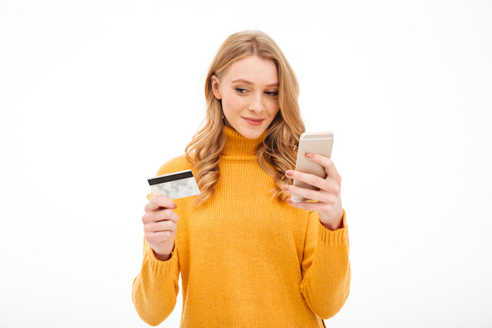 Chica pagando su tarjeta de crédito desde el móvil