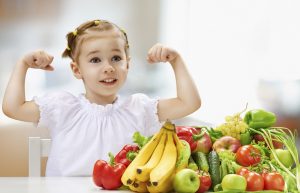 niña con frutas y verduras